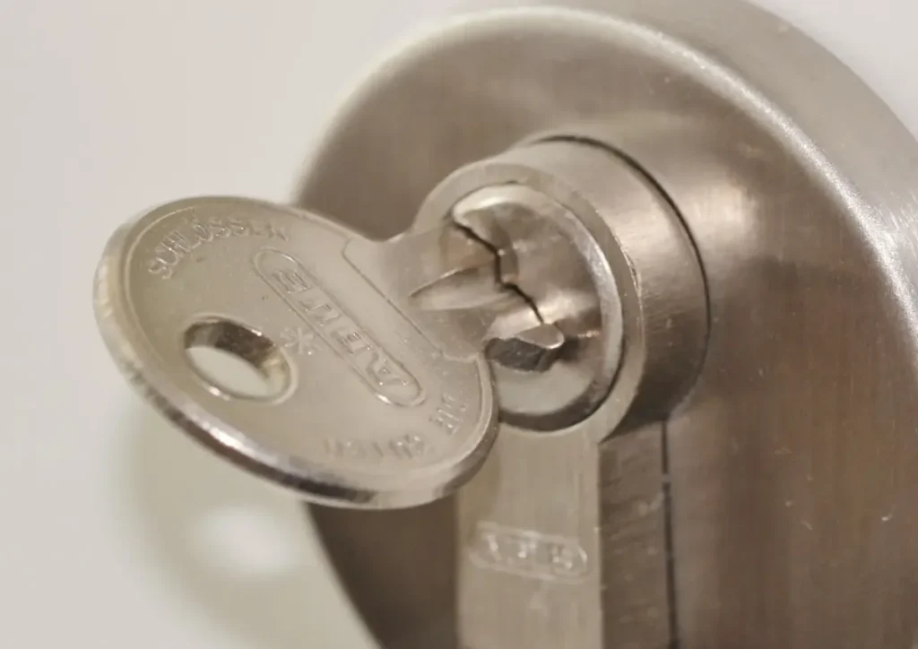 Key inserted in a door lock cylinder – how to choose a trustworthy locksmith in Sheffield before a lock is drilled or replaced, Locksmith Sheffield